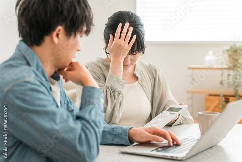фотографія A young Asian couple struggling with household finances due to rising prices (de