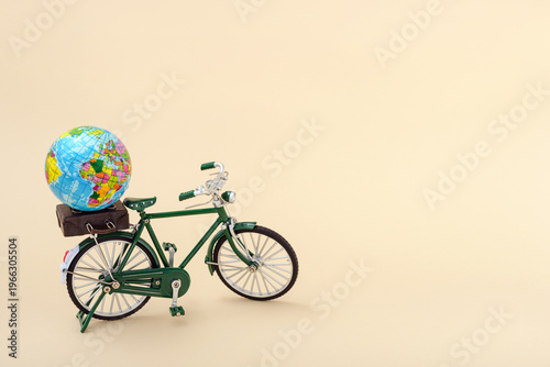 Eatrh globe and suitcase on a green bicycle