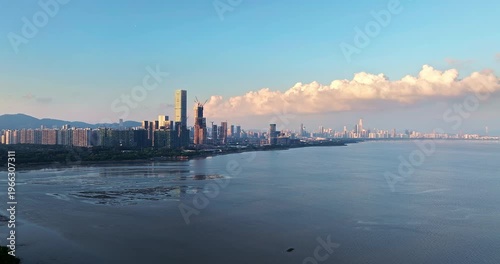 Aerial view of Shenzhen coastal city skyline with modern skyscrapers and sea at sunset, Guangdong, China.