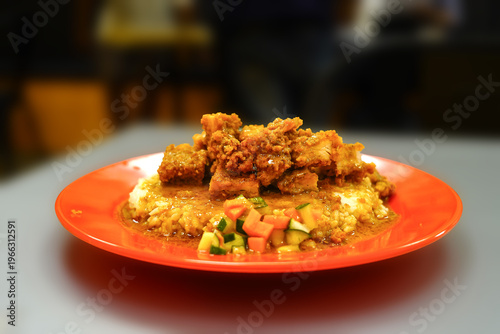 Wallpaper Mural Close-up shot of a savory dish with fried meat and vegetables on a vibrant red plate atop a gray table with a blurred background. Torontodigital.ca