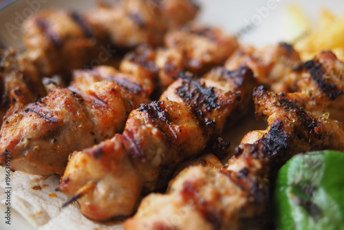 Photos Grilled chicken kebabs served on a plate with vegetables