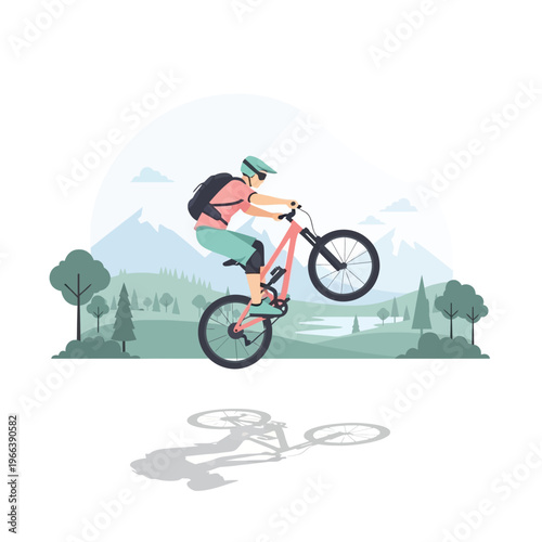 Mountain biker performing a wheelie on a trail with scenic mountain landscape background