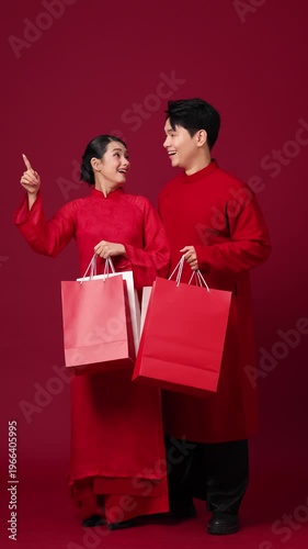 Asian couple stands with shopping bags, showcasing a modern, cheerful lifestyle. The theme is 