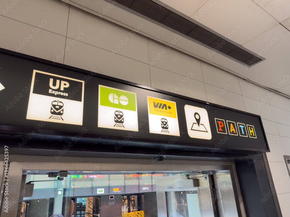 Naklejka premium Transit sign with UP Express, GO, VIA Rail, and PATH logos inside a transit station - Toronto, Canada - June 24, 2025