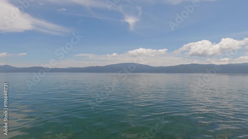calm lake water wave motion with mountain in morning