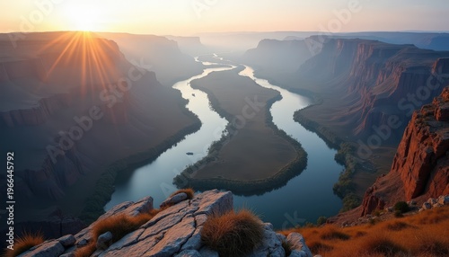 Golden Sunrise Illuminates Winding River Through Vast Canyon Landscape with Rocky Outcrops and Hazy Horizon Dramatic