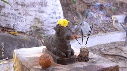 Offering prayers to Nandi Maharaj with incense and flowers.  Lord shiva vehicle sacred bull 'Nandi'.