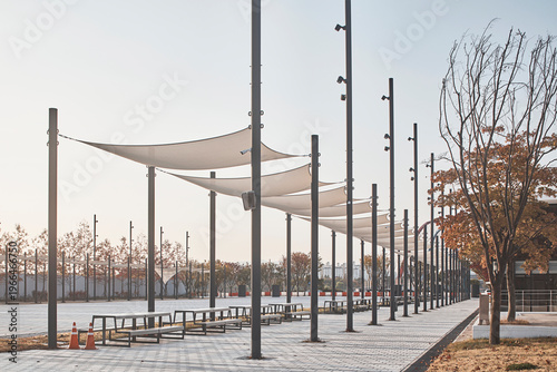 Fotografie Tree lined public plaza with tensile shade structures in autumn landscape