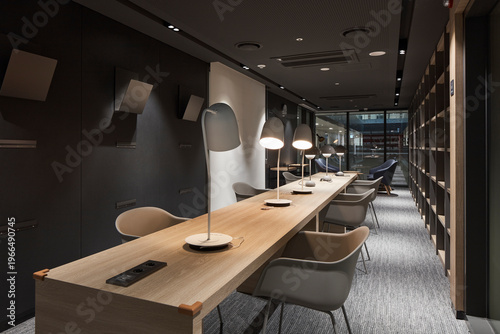 Cozy study library with long communal desk and warm task lighting