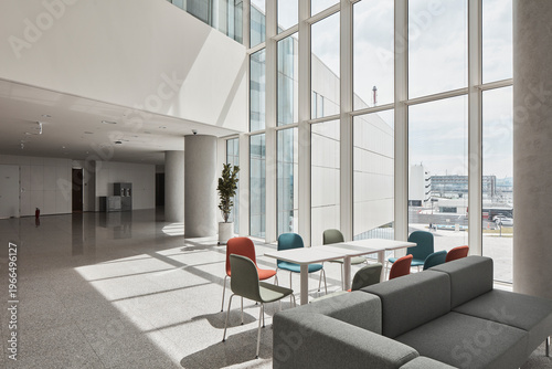 Grand lobby lounge with tall glazing and colorful seating in modern building