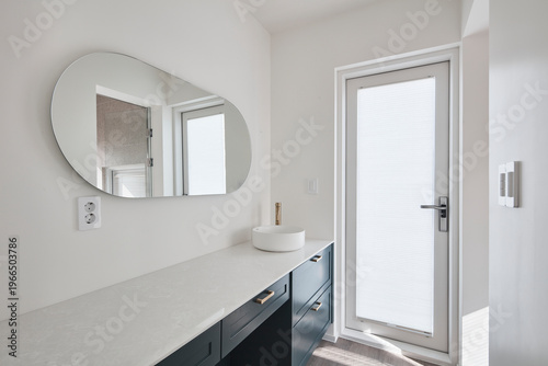 Tableau sur toile Minimal white vanity with round mirror beside glass door in bright bathroom