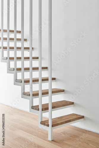 Floating wood stair in bright white double height interior