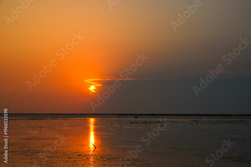 Natural Sunset Sunrise Over Sea, Bright Dramatic Sky And Dark Ground. Countryside Landscape Under Scenic Colorful Sky At Sunset Dawn Sunrise. Sun Over Skyline, Horizon. Warm Color.