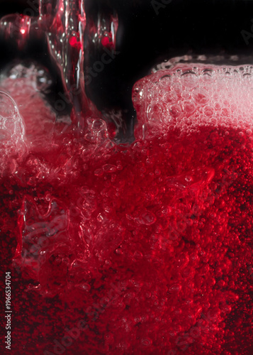 Close-up of red wine bubles in a transparent glass on black backgrond