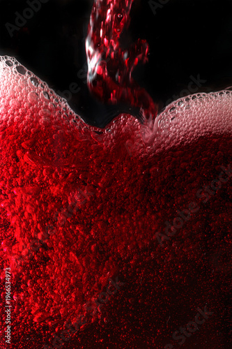 Close-up of red wine bubles in a transparent glass on black backgrond