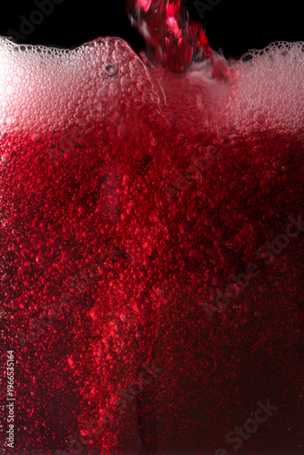 Close-up of red wine bubles in a transparent glass on black backgrond