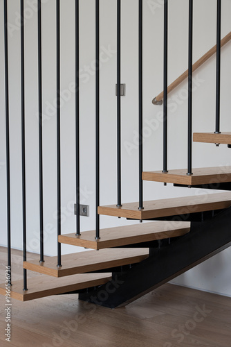 Floating wood stairs with black steel balustrade in modern home
