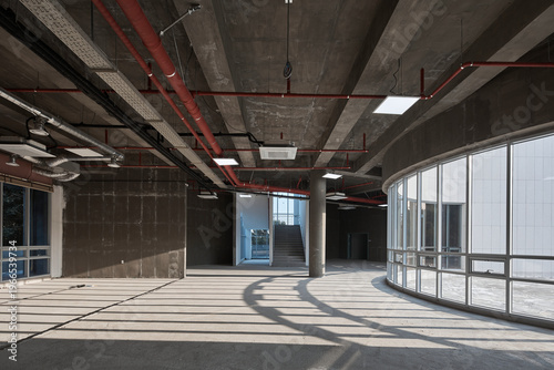Sunlit atrium corner with black ceiling and large glazed wall