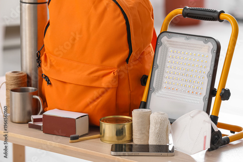 Tableau sur toile Emergency backpack, portable floodlight and necessities on table at home