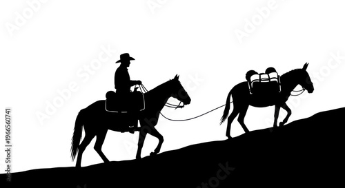 A cowboy rides a horse leading another horse up a hill