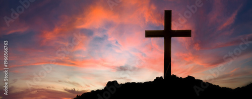 The cross standing on meadow sunset and bokeh background.Cross on a hill as the morning sun comes up for the day.The cross symbol for Jesus christ.Christianity, religious, faith, Jesus or belief.