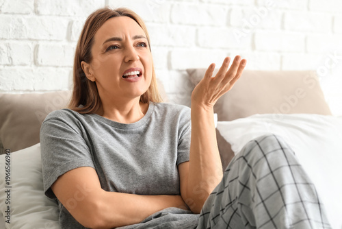 Angry mature woman lying in...