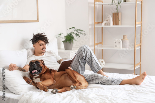Young man with Boxer dog re...