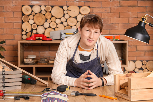 Young carpenter at table in...