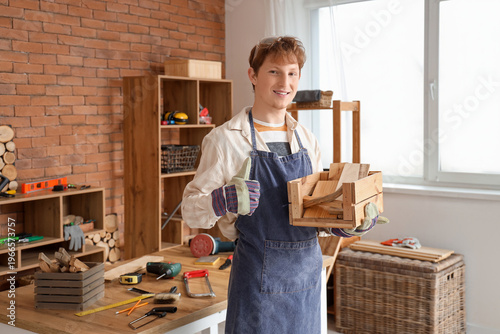 Young carpenter with box of...