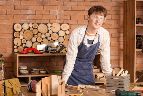 Young carpenter at table in...