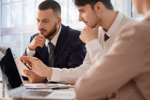 Thoughtful business men with document at mediator's office