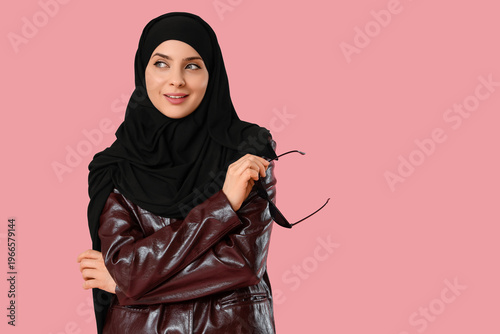 Photos Beautiful young happy stylish Muslim woman in hijab with sunglasses on pink back