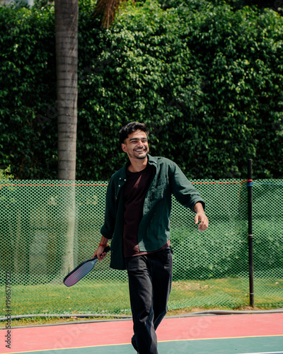 Indian Man playing pickleball on an outdoor court, showcasing an active lifestyle, sports activity, and recreational fitness. Concept of modern sports, healthy living, and outdoor games.