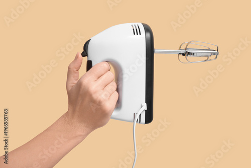 Woman holding electric mixe...