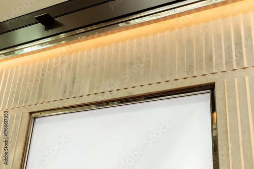 Storefront in a retail area shows an empty space where a logo can be placed. The design features clean lines and a light color scheme. Ideal for various brands and shops