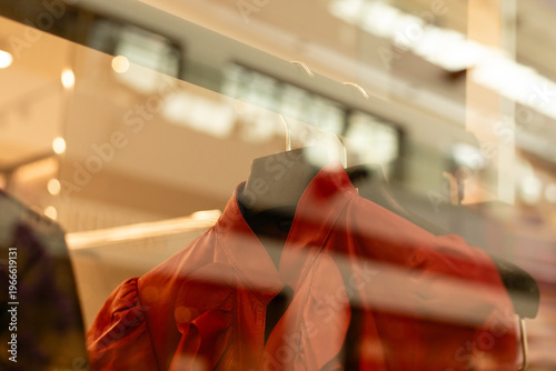 Foto Clothing hangs on a rack inside a store window