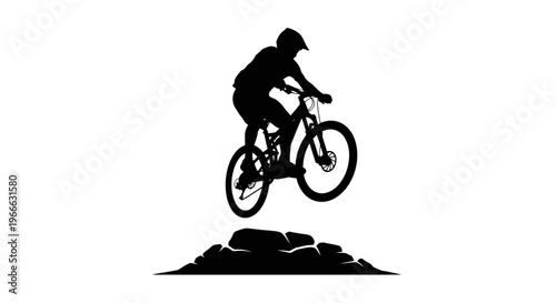 Mountain biker jumping mid air over rocks dramatic black silhouette