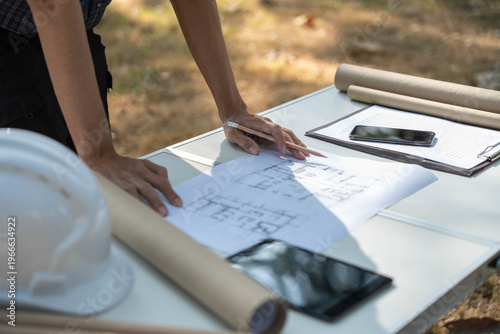 Photos Architect checking blueprint on working table at construction site