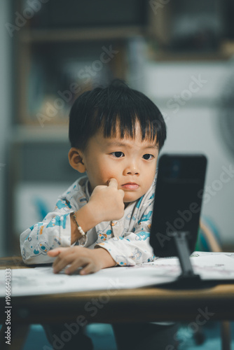 Toddler Watching Smartphone While Drawing at Table
