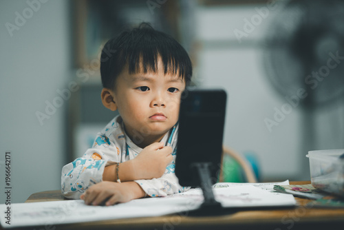 Toddler Watching Smartphone While Drawing at Table