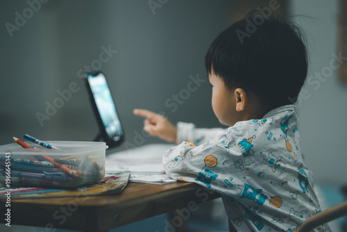 Toddler Watching Smartphone While Drawing at Table
