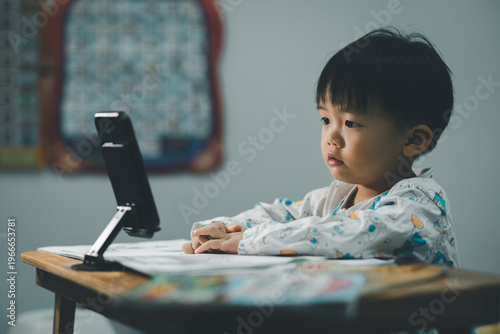 Toddler Watching Smartphone While Drawing at Table