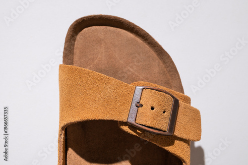 Close up of brown leather sandals. Summer footwear made of genuine leather, soft nubuck, cork soles. Details of fashionable birkenstock sandals, unisex beach and city shoes