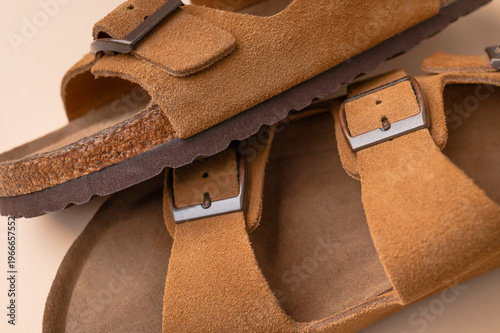 Close up of brown leather sandals. Summer footwear made of genuine leather, soft nubuck, cork soles. Details of fashionable birkenstock sandals, unisex beach and city shoes