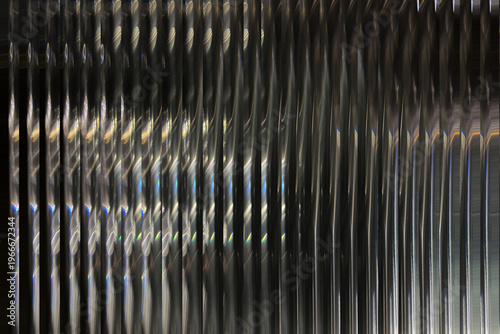 A close-up view of a shiny metal wall with vertical lines illustration