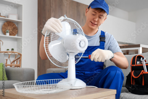 Male technician repairing e...
