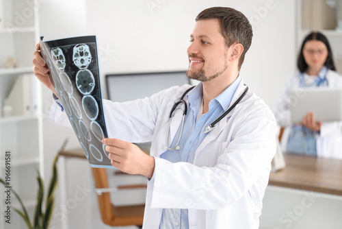 Male doctor with MRI scan in clinic