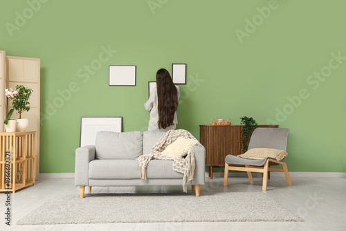 Young woman hanging blank p...