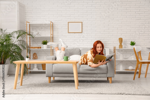 Young woman reading magazin...