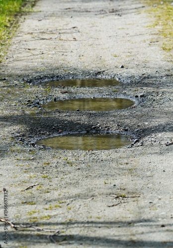 Картината върху платно Three potholes filled with rainwater